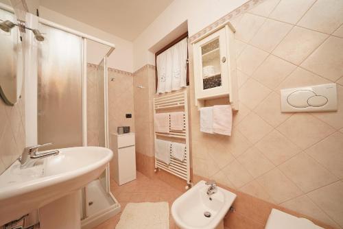 ein weißes Bad mit einem Waschbecken und einem WC in der Unterkunft Messaga in Toscolano-Maderno