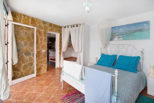 a bedroom with a bed with blue pillows at Finca Fani 2 in Agüimes