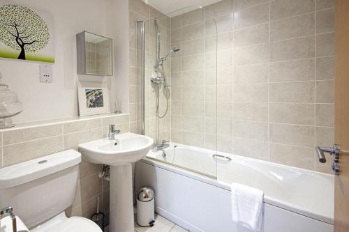 a bathroom with a sink and a toilet and a bath tub at Howells Mere 88, Tranquility P in Somerford Keynes