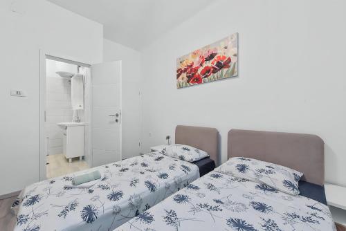 sypialnia z 2 łóżkami i zdjęciem na ścianie w obiekcie Little flower in city center w mieście Rijeka