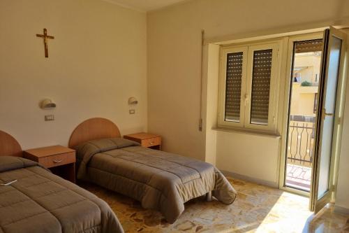 a bedroom with two beds and a cross on the wall at Palazzo Sant'Antonio in Rome