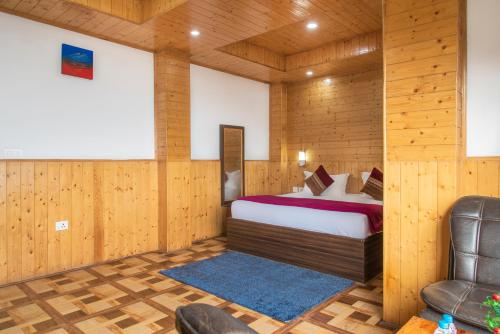 a bedroom with a bed and a chair in a room at Mountain View New Kufri in Cheog