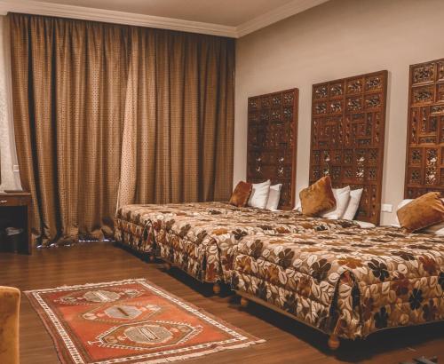 a hotel room with two beds and a rug at Chtaura Park Hotel in Chtaura