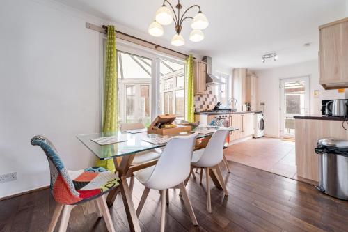 a kitchen and dining room with a table and chairs at Dwellers Delight Living Ltd Serviced Accommodation, Chigwell, London 3 bedroom House, Upto 7 Guests, Free Wifi & Parking in London