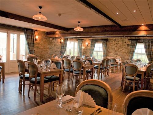a restaurant with tables and chairs in a room at Duke of Wellington Inn in Corbridge