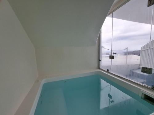 a swimming pool in a room with a window at Dreaming View Suites in Imerovigli