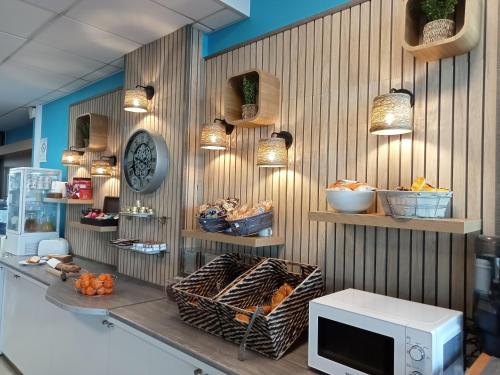 een keuken met een aanrecht met een magnetron aan de muur bij Séjours & Affaires Rennes de Bretagne in Rennes