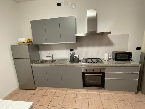 uma cozinha com um lavatório e um fogão forno superior em Sole dei Colli em Vo Euganeo