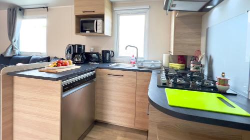 une cuisine avec une planche de coupe verte sur un comptoir dans l'établissement L'incontournable Tout Confort Camping Siblu, à Fréjus