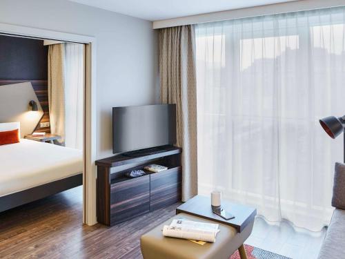 a hotel room with a bed and a large window at Aparthotel Adagio Edinburgh Royal Mile in Edinburgh