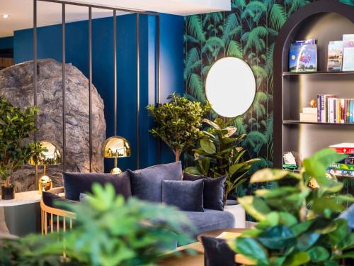 a living room with blue walls and plants at Aparthotel Adagio Edinburgh Royal Mile in Edinburgh