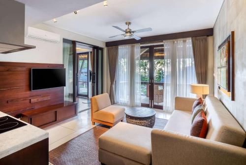 a living room with a couch and a tv at Sundancer Residences and Villas Lombok in Sekotong