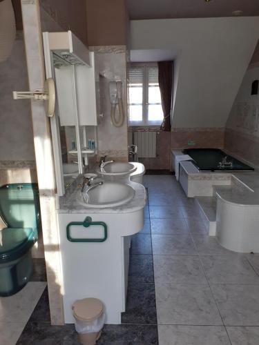 La salle de bains est pourvue de 2 lavabos, de toilettes et d'une baignoire. dans l'établissement LA LAUZERAIE, à La Bourboule