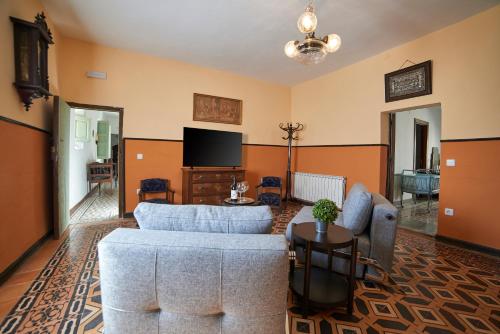 a living room with a couch and a tv at Casona Alcarria in Pastrana