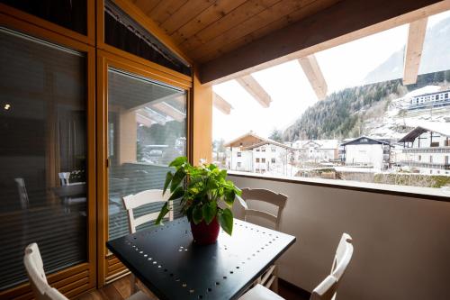 einen Tisch und Stühle auf einem Balkon mit einer Pflanze in der Unterkunft Feldmilla Design Hotel in Sand in Taufers