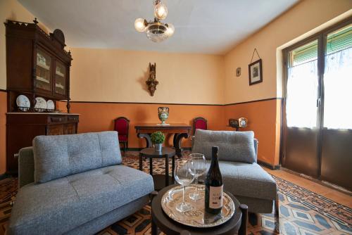 a living room with two chairs and a bottle of wine at Casona Alcarria in Pastrana