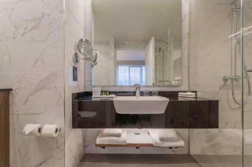 a bathroom with a sink and a mirror at Hyatt Centric The Liberties Dublin in Dublin