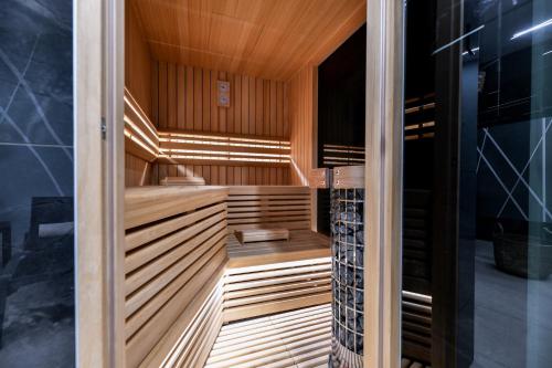 un sauna avec des boiseries et une douche en verre dans l'établissement CROWONDER Apartments & Rooms OAZA with heated Swimming Pool and Sauna, à Turanj