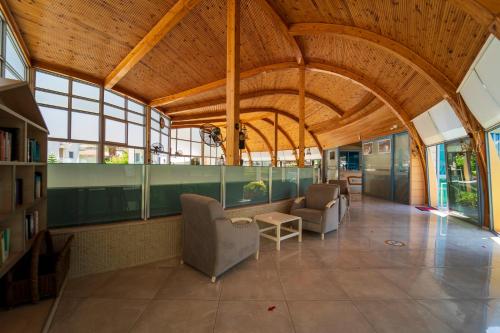 a large room with a large wooden ceiling and chairs at Belcehan Hotel in Oludeniz