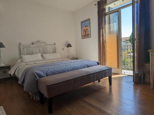 a bedroom with a large bed and a sliding glass door at La Fontaine aux Poissons Rouges in Moussac