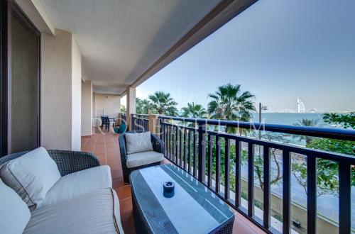 un balcón con sofá, mesa y el océano en Anantara Palm Jumeirah Dubai Luxurious Home en Dubái