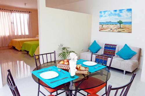 uma sala de jantar com uma mesa de vidro e cadeiras em Ocean Dreams Galapagos em Puerto Ayora