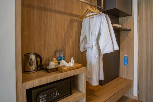 a bathroom with a robe hanging on a wall at Chewa Khong Nakhon Phanom - SHA Certified in Nakhon Phanom