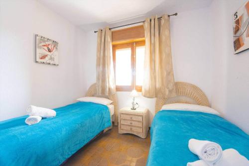 dwa łóżka pojedyncze w pokoju z oknem w obiekcie Villa Ortembach- PlusHolidays w mieście Calpe