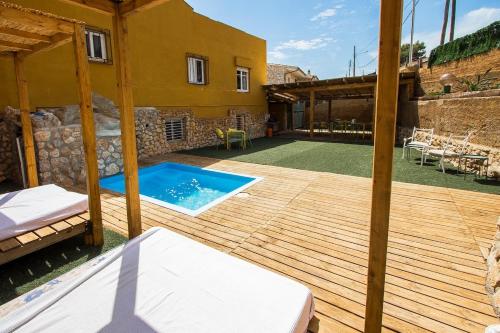 una terraza de madera con piscina y una casa en Catalunya Casas Splendid Sanctuary with private pool 15km to Sitges!, en Olèrdola