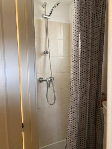 y baño con ducha y cortina de ducha. en Une chambre chez nous, à 12 minutes de Paris, en Malakoff