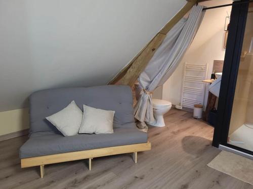um sofá com três almofadas num quarto em AU BAIN Normand : bain nordique et détente. em Goderville