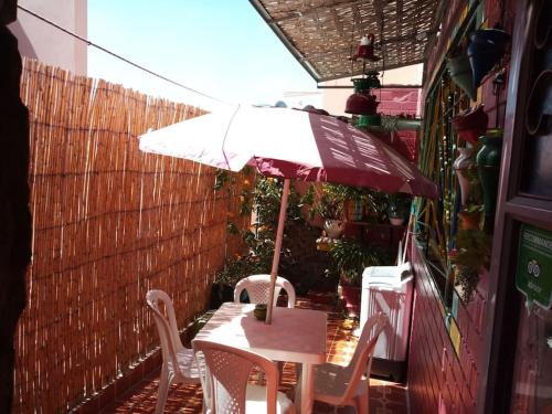 a table and chairs with an umbrella on a patio at Margueritte vacancy apartment in Casablanca