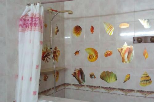 a bathroom with a shower with seashells on the wall at Margueritte vacancy apartment in Casablanca