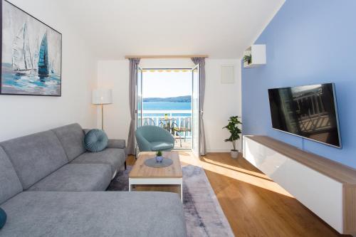 uma sala de estar com um sofá e uma televisão em Apartments Ana em Trogir