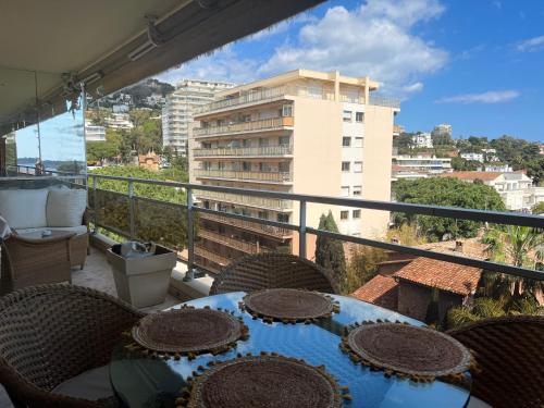 un balcón con mesa y sillas y un edificio en Les Roses by Welcome to Cannes en Cannes