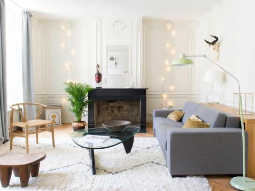 uma sala de estar com um sofá e uma lareira em Chez Laurence Du Tilly em Caen