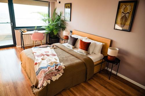 - une chambre avec un lit et une grande fenêtre dans l'établissement Rooftop Apt with Large Harbor View Terrace, à Constanţa