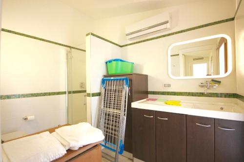 ein Badezimmer mit Waschbecken und Spiegel in der Unterkunft Villa Franca by Wonderful Italy in San Teodoro