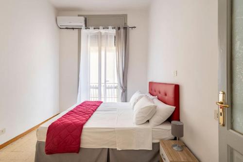 a bedroom with a red and white bed with a window at Mare e Monti in Scilla