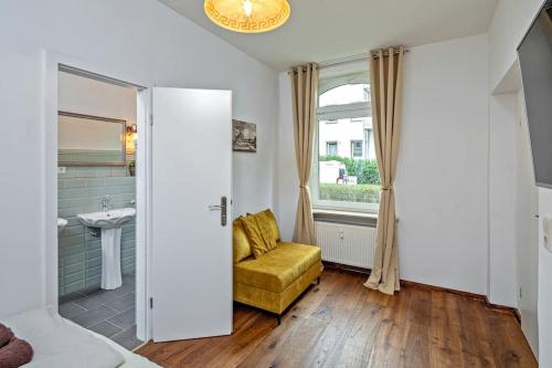 ein Badezimmer mit einem gelben Stuhl und einem Fenster in der Unterkunft Dresden Bakery Appartement in Dresden