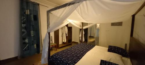 a bedroom with a bed with a canopy at Residence La Casa Blanca in Bamako