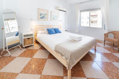 ein Schlafzimmer mit einem großen Bett und einem karierten Boden in der Unterkunft AlohaMundi Plaza de Cuba in Sevilla