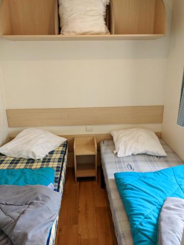 deux lits dans une petite pièce avec dans l'établissement Bungalow chaleureux à Saint-Julien-en-Born avec piscine partagée, à Saint-Julien-en-Born