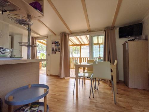 kuchnia i jadalnia ze stołem i krzesłami w obiekcie Bungalow chaleureux à Saint-Julien-en-Born avec piscine partagée w mieście Saint-Julien-en-Born