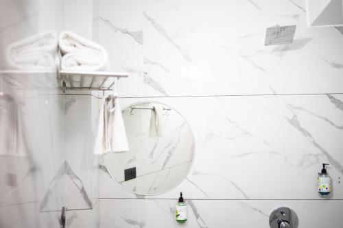 a white bathroom with a mirror and a sink at Hotel Banjara Heritage in Udaipur