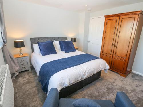a bedroom with a large bed with blue pillows at Artro in Cemaes Bay