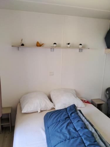 - une chambre avec 2 lits et des étagères sur le mur dans l'établissement Bungalow charmant à Saint-Julien-en-Born avec piscine partagée, à Saint-Julien-en-Born