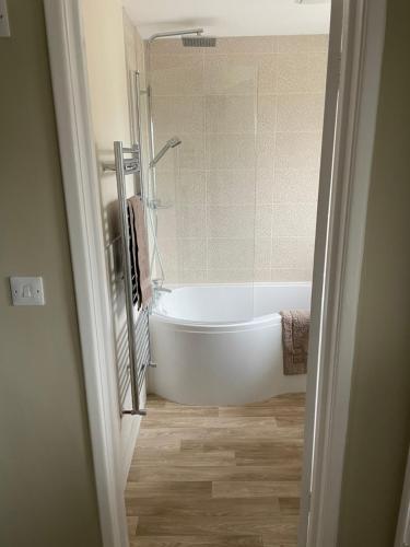 a bathroom with a white tub and a shower at Till Cottage 3 Fenton Hill Farm in Wooler
