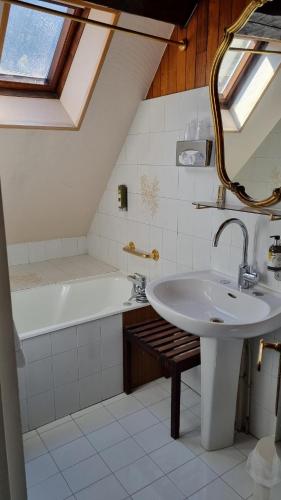 uma casa de banho com um lavatório e uma banheira em Hotel de la Poste em Corps
