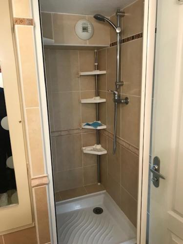 une salle de bain avec une douche avec une porte vitrée dans l'établissement LES REFLETS F5, à Saint-Cyprien